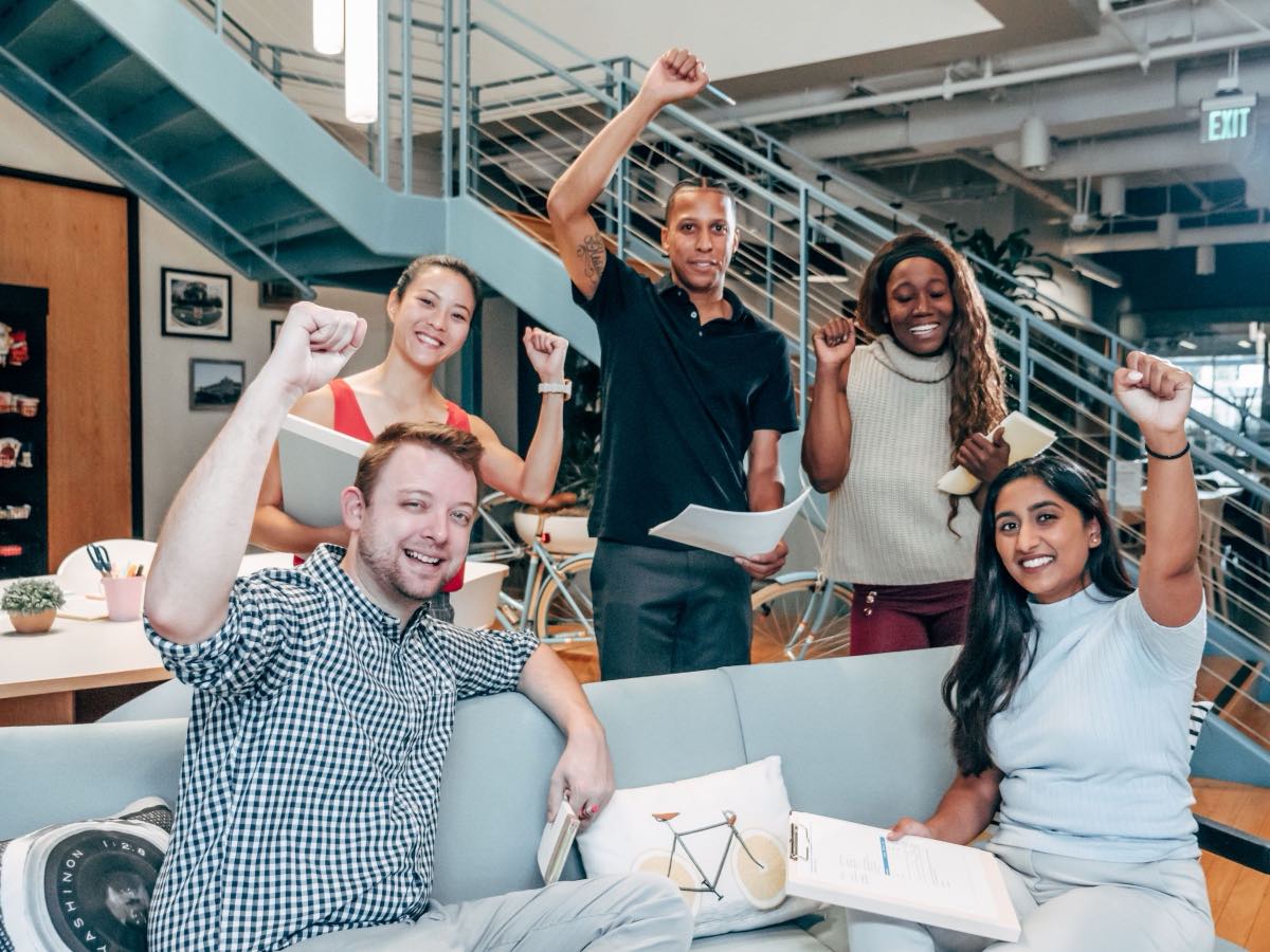 A startup team celebrating growth from their SaaS marketing strategies
